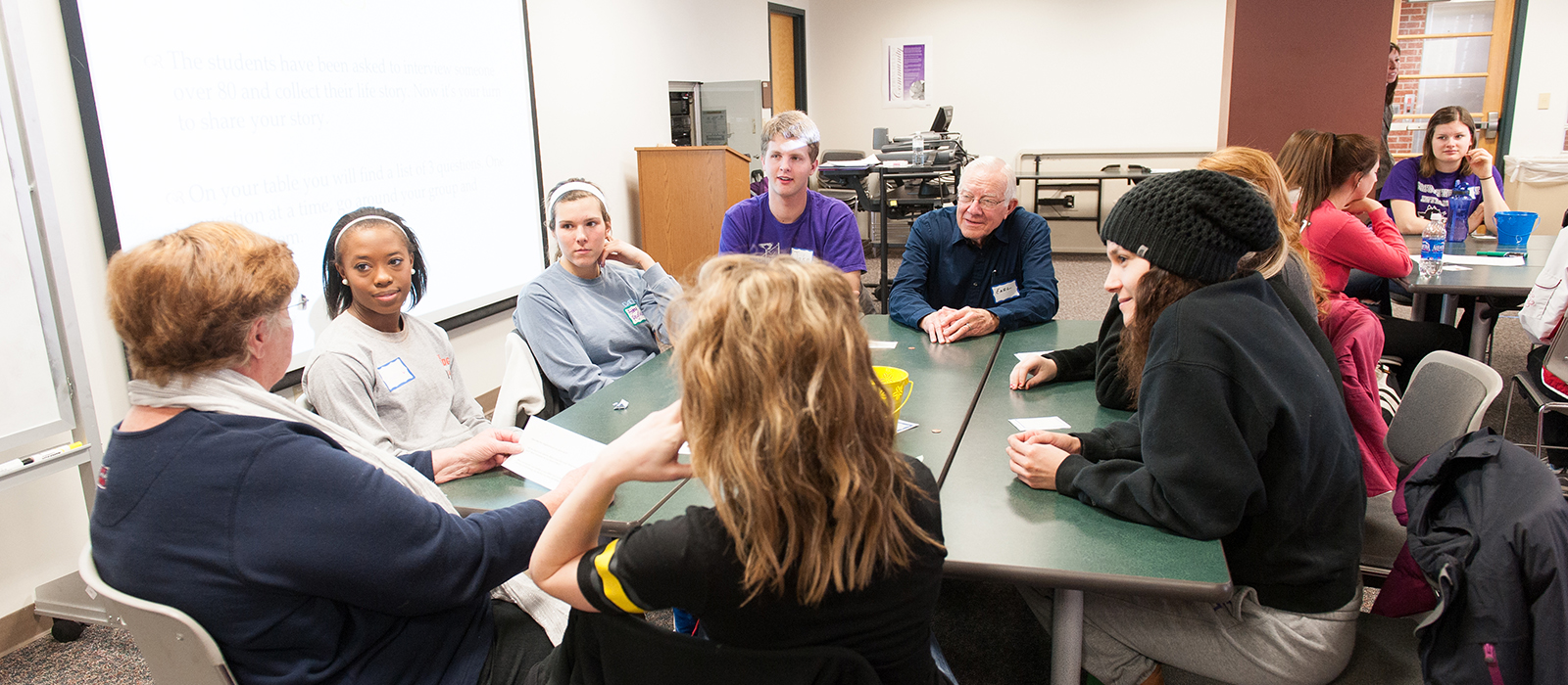 Students and senior adults around table