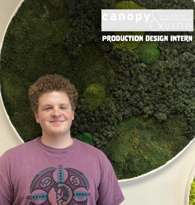 Declan Taylor posing infront of the Canopy & Vine sign