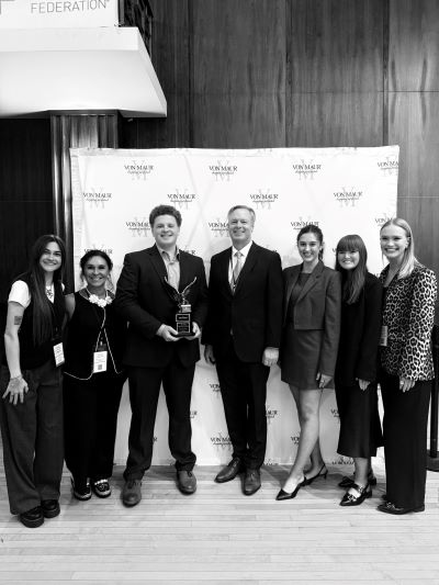 Students posing with the owner of Von Maur at the event.