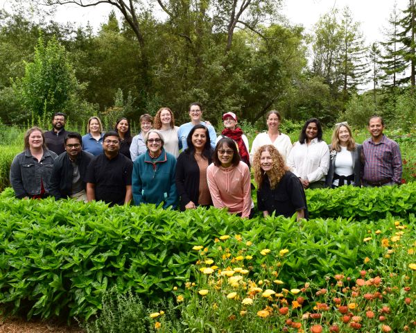 The team of researching faculty posing together amongst the green natural research environment