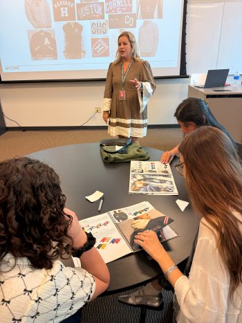 Students listening to a presentation about product purchasing while viewing product magazines
