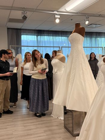 Students looking at a variety of wedding dress setup on display for their visit to Essense of Australia