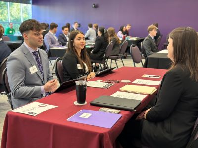 2025 Professional Connections Event zoomed up image of two students talking with a firm at their designated table