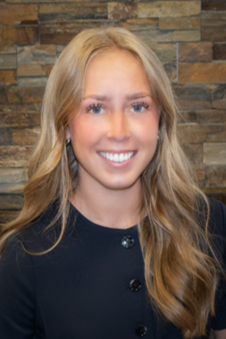 Headshot of Katie Dinkel with brick background