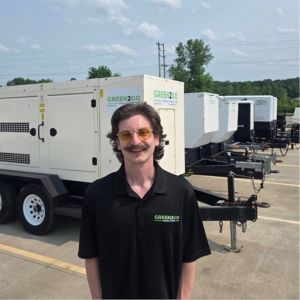 Ethan Rice posing outside in front of large generators
