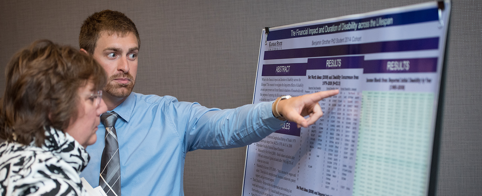 Student discussing research results in poster presentation