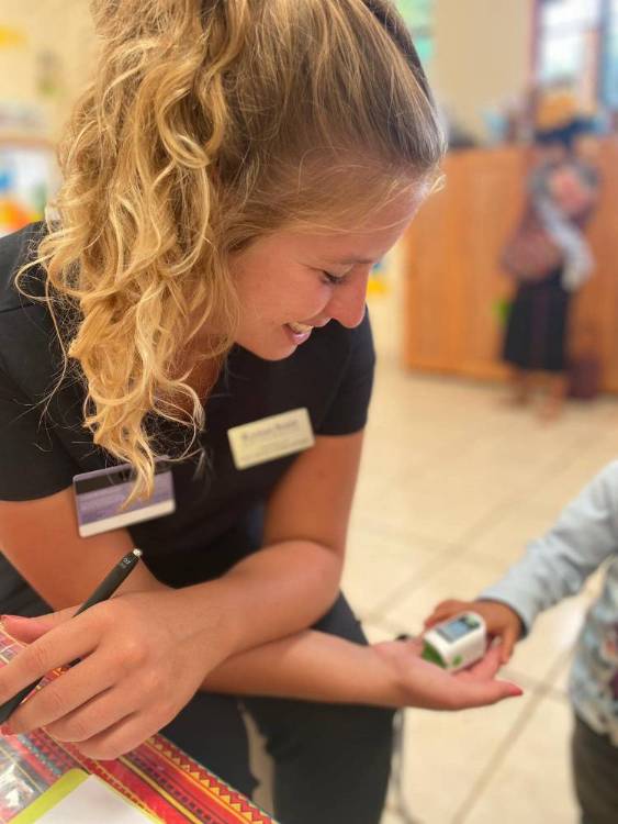 K-State student Vivan Strahm plays with a Maya child during a health fair.