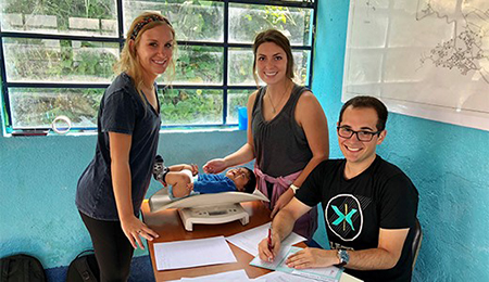 Students weighing a baby on Guatemala service trip