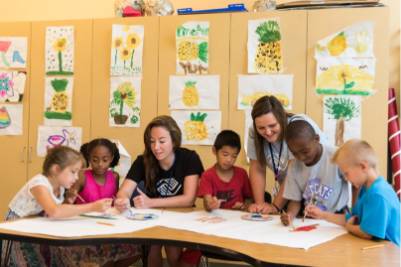 Students with young children around a table