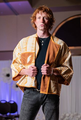 Model in orange jacket and black pants
