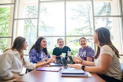 Students sitting at table in Hoffman lounge