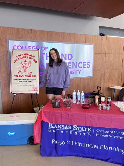 Student Standing with Event Table