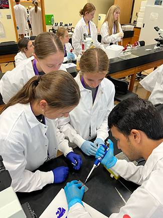 Campers preparing slides for microscope